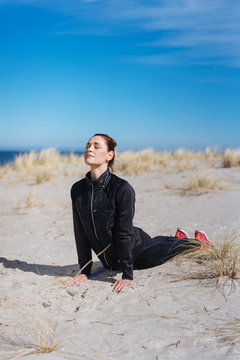Fit healthy young woman exercising on a beach