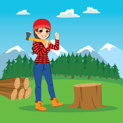 Obraz na płótnie Canvas Beautiful brunette female lumberjack cutting tree with axe on forest background