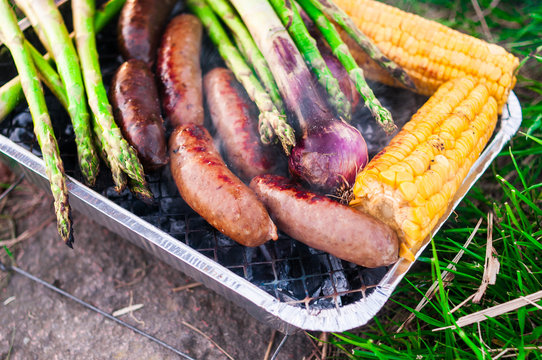 Grilled vegetables and sausages close up with smoke