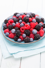 Fresh raspberries in a plate on a  vintage background.