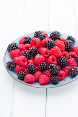 Fresh raspberries in a plate on a  vintage background.
