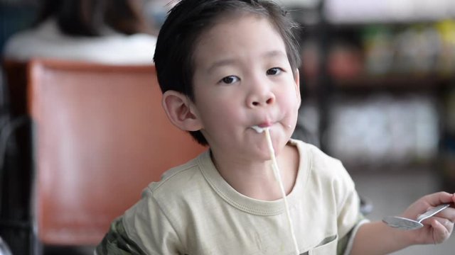 Cute Asian child eating Spaghetti Carbonara in restaurant slow motion 