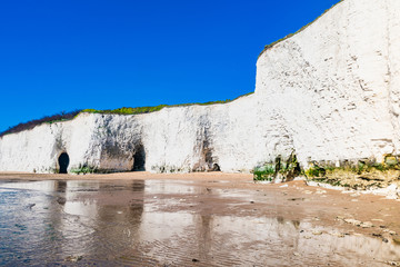 View of white chalk stacks and cliffs, sea at low tide and beach in Kingsgate Bay, Margate, East...