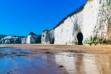 View of white chalk stacks and cliffs, sea at low tide and beach in Kingsgate Bay, Margate, East...