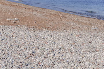 Stony pebble foreground beach and blue wave sea