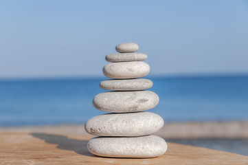 Stress balanced several Zen stones on blurred sea and beach