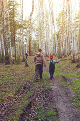 two kids walking in the birch forest