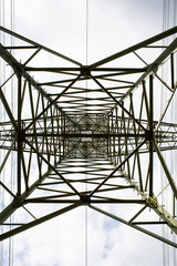 Transmission tower bottom view. Power tower on cloudy sky. Electricity pylon structure for power line. High voltage post outdoor. Energy and ecology