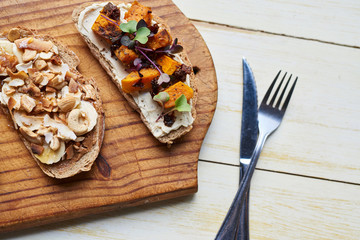 Rustic open faced sandwiches sitting on a table with cutlery