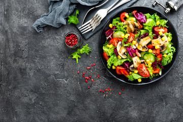 Salad with fresh and grilled vegetables and mushrooms. Vegetable salad with grilled champignons. Vegetable salad on plate. Healthy vegetarian food