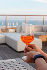 female hand with glass of aperol spritz