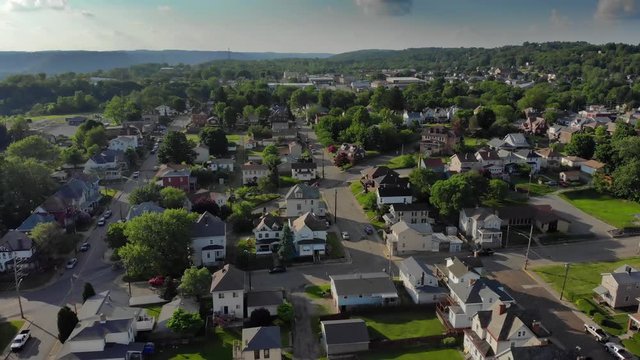 A slow reverse aerial establishing shot of the residential neighborhood in a small Pennsylvania town. Pittsburgh suburbs.  	