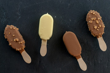 assorted mini ice creams on stick on black