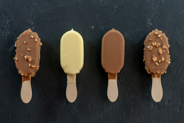 assorted mini ice creams on stick on black