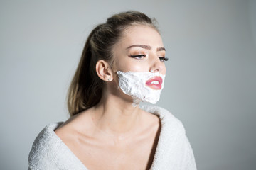 Side view woman with shaving foam on her face isolated on gray background. Girl with high ponytail...