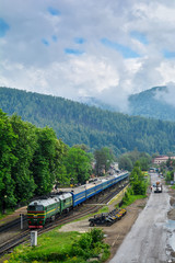 Train on the station with mountains in the background