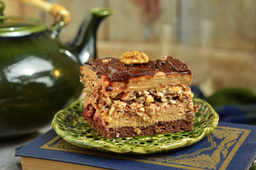 A square piece of nut cake with butter cream and chocolate sauce