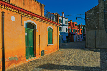 Overview of colorful terraced houses in an alley, in the sunset at the city center of Venice, the historic and amazing marine city. Located in the Veneto region, northern Italy. Retouched photo