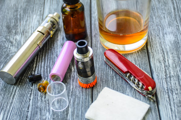 Still life with e-cig and jiuce on the wooden background