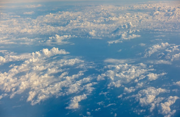 Naklejka premium Wing of an airplane flying above the clouds. Wing of the plane on blue sky background., Traveling concept..