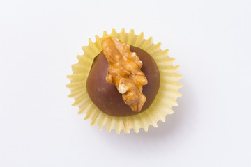 Homemade chocolate truffle. Known as Camafeu in Brazil. Flat lay of candy ball on white table.