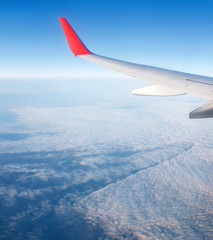 Obraz premium View from window of airplane on the blue sky and wing with sharklet