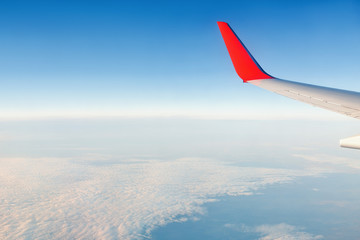 View from window of airplane on the blue sky and wing with sharklet