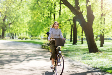 Attractive young woman cycling through the park