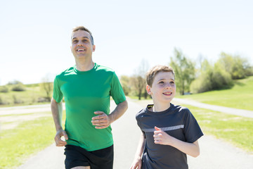 father with son sport running together outside