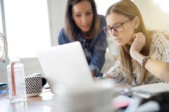 Businesswomen working together on laptop
