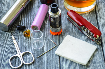 Still life with e-cig and jiuce on the wooden background