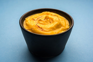 Amrakhand OR Mango Shrikhand / srikhand is popular Indian dessert served with saffron toppings in a bowl