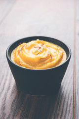 Amrakhand OR Mango Shrikhand / srikhand is popular Indian dessert served with saffron toppings in a bowl