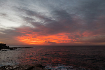 Fototapeta na wymiar Red cloudy sky before the sunrise at Sydney coastline.