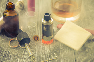 Still life with e-cig and jiuce on the wooden background