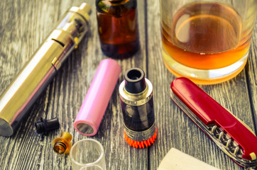 Still life with e-cig and jiuce on the wooden background