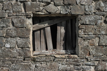 Boarded up window in stone building