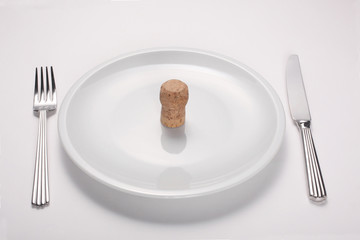 alcoholism concept: wine cork on an empty white dish isolated on white background
