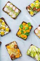 Variety of sandwiches with cream cheese, hummus, avocado and tomatoes
