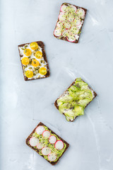 Variety of sandwiches with cream cheese, hummus, avocado and tomatoes