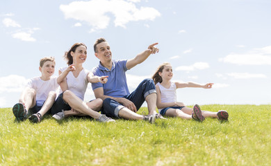 Family of four outdoors in a field having fun