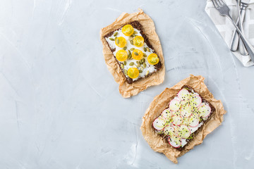 Variety of sandwiches with cream cheese, radish, tomatoes and micro greens