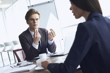 Businessman and businesswoman at office working together sitting at table drinking hot coffee discussing project concentrated woman close-up