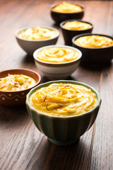 Shrikhand & Amrakhand served in different size bowl in group. Selective focus