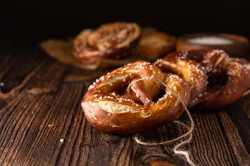 Freshly baked homemade soft pretzel with salt on rustic table. Perfect for Octoberfest. 