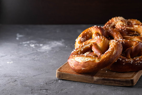Freshly baked homemade soft pretzel with salt on rustic table. Perfect for Octoberfest. 