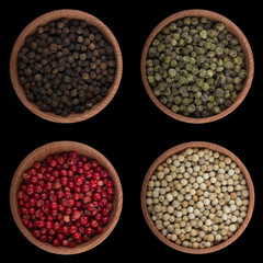 set of peppercorn in wooden cups isolated on black background. top view