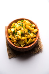 Chatpate Masala Aloo Sabzi fry OR Bombay potatoes served in a bowl, selective focus