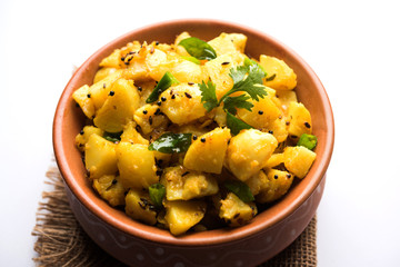 Chatpate Masala Aloo Sabzi fry OR Bombay potatoes served in a bowl, selective focus