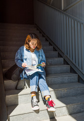 Girl sitting on the stairs and reading book